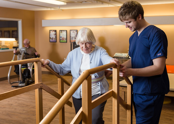 Nurse helps patient climb stairs in the Rehabilitation Center