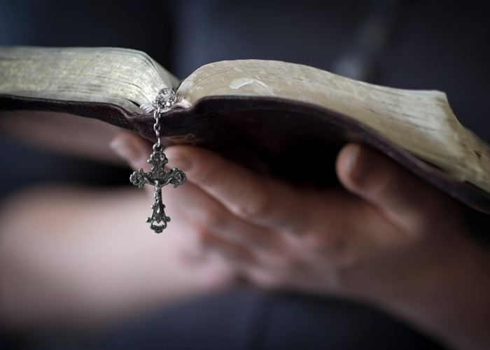 Close-up photograph of hands holding a bible