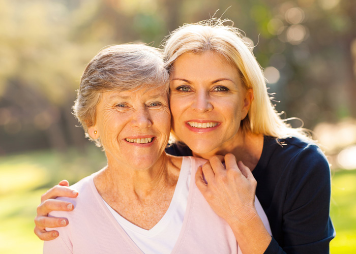 Mother and daughter smiling for a photo.